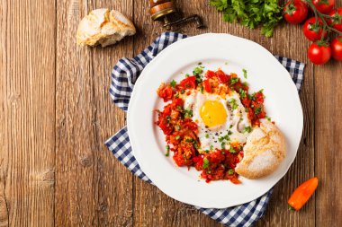 Shakshouka, domates sosunda haşlanmış yumurta, acı biber, soğan. Üst görünüm. 