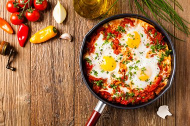 Shakshouka, domates sosunda haşlanmış yumurta, acı biber, soğan. Üst görünüm. 