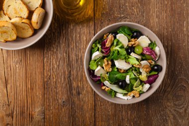 Keçi peynirli, üzümlü ve cevizli İtalyan bahar salatası. Kızarmış ekmekle servis edilir. Üst görünüm. 