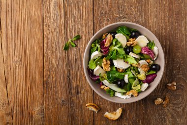 Keçi peynirli, üzümlü ve cevizli İtalyan bahar salatası. Kızarmış ekmekle servis edilir. Üst görünüm. 