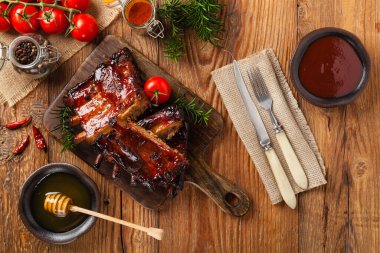 Kızarmış domuz pirzolası ve bbq sosu. Tahta bir tahtanın üzerinde servis edilmiş. Üst görünüm.