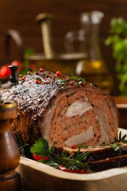 Bütün olarak kızartılmış, kıymalı domuz boynuyla doldurulmuş. Ön manzara. Doğal ahşap zemin.