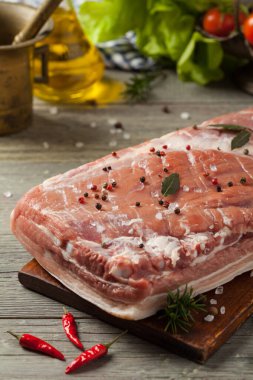 Ahşap arka planda çiğ domuz pastırması. Ön görünüm.