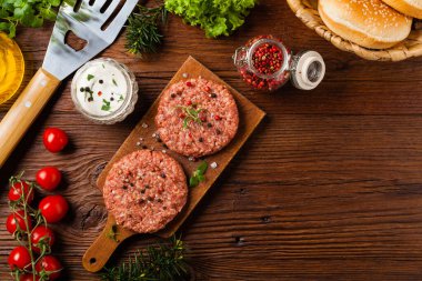Çiğ sığır burger, ızgara için hazır. Izgara aksesuarları. Kavram. Açıklama için boş yer. Üst görünüm.