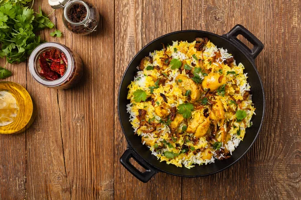 Biryani和鸡肉 传统的印度米饭和鸡肉 用香料和酸奶腌制而成 天然木制背景 — 图库照片