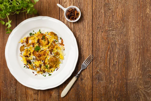 Biryani ve tavuk. Geleneksel Hint yemeği ve baharat ve yoğurt ile marine edilmiş tavuk. Doğal ahşap arka plan. 