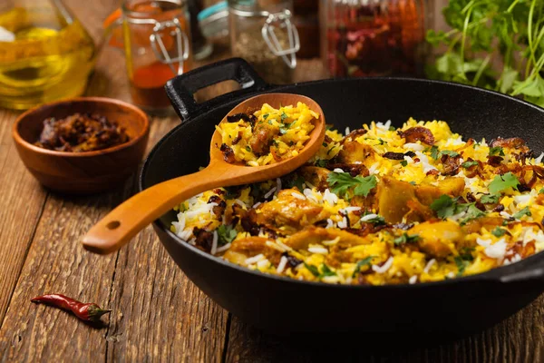 チキンとビリヤニ スパイスとヨーグルトでマリネ米と鶏の伝統的なインド料理 正面図 天然木の背景 — ストック写真