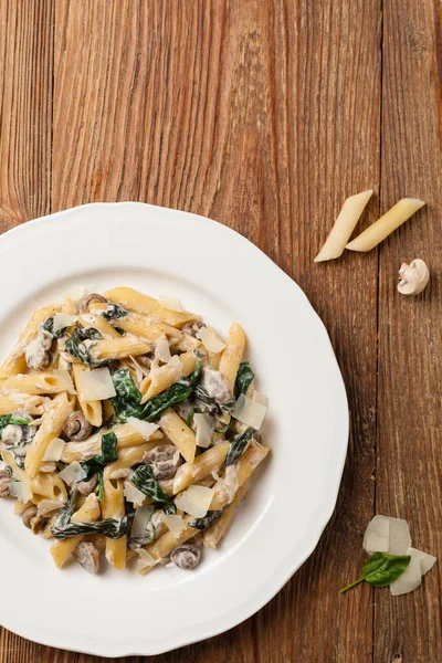 Penne Pasta Met Spinazie Champignons Bestrooid Met Kaas Bovenaanzicht — Stockfoto