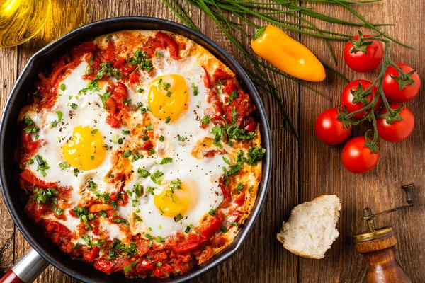 Shakshouka, domates sosunda haşlanmış yumurta, acı biber, soğan. Üst görünüm. 