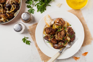 Kızarmış tavuk ciğeri ve soğan. Üst Manzara. Taş arkaplan.