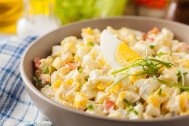 Kerevizli, turşulu, biberli ve mayonezli hafif yumurta salatası. Arka planda bir kasede servis edilmiş. Ön görünüm.