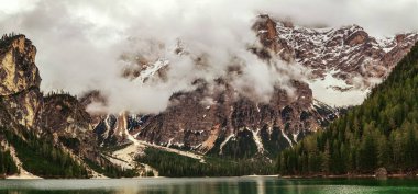 Braies Gölü 'ndeki dağ zirvelerinden inen sisin güzel manzarası. Panorama.