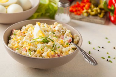 Kerevizli, turşulu, biberli ve mayonezli hafif yumurta salatası. Arka planda bir kasede servis edilmiş. Ön görünüm.