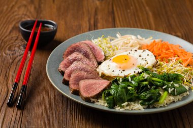 Lahanalı Kore bifteği, ıspanak ve kızarmış yumurta. Ön görünüm.