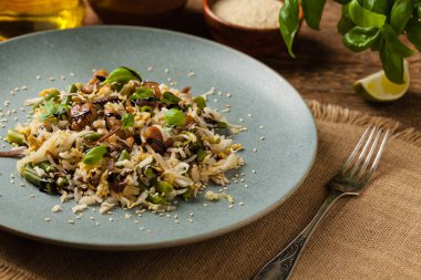 Kızarmış dana eti, pilav, Çin lahanası ve mantar. Susam ve soya sosu serpilmiş. Ön görünüm. 