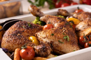 Kızartma tavasında sebzelerle pişirilmiş tavuk budu. Soslu ve patatesli..