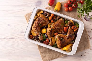 Kızartma tavasında sebzelerle pişirilmiş tavuk budu. Soslu ve patatesli..