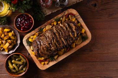 Bütün domuz boynunu kızarttım. Soğan dilimleriyle doldurulmuş. Fırında patatesle servis edilir. Doğal ahşap zemin