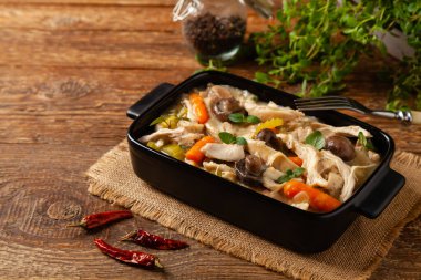 Geleneksel mantar ve sebzeli tavuk güveci. Tavuk güveci. Siyah kaplarda servis edilir..