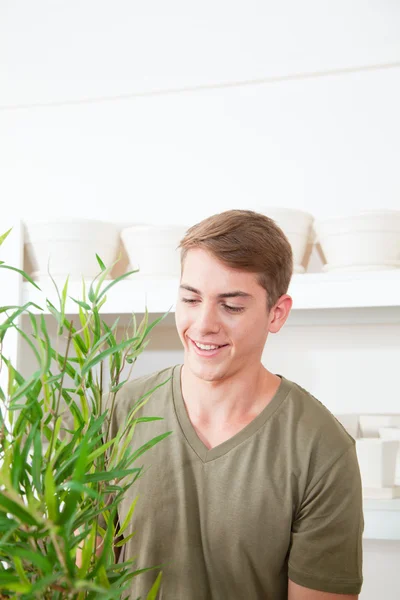 Lächelnder Mann mit einer Pflanze — Stockfoto