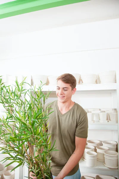 Lächelnder Mann mit einer Pflanze — Stockfoto