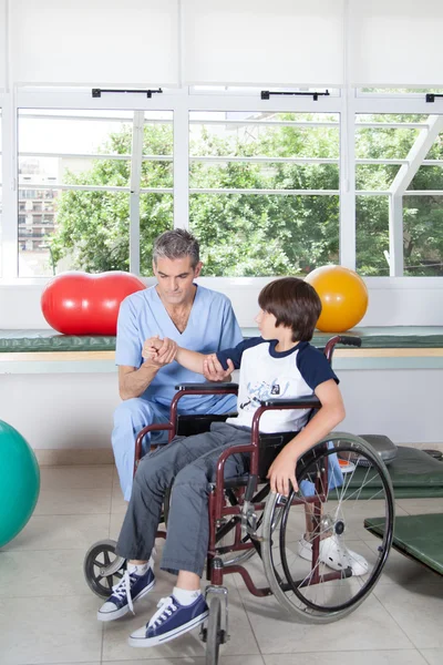 Terapeuta trabajando con niño en silla de ruedas —  Fotos de Stock