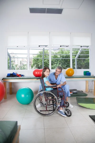 Terapeuta con chica en silla de ruedas —  Fotos de Stock