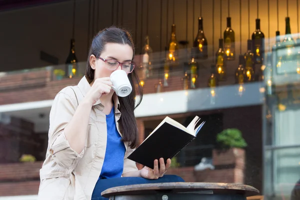 Frau trinkt Kaffee und liest — Stockfoto