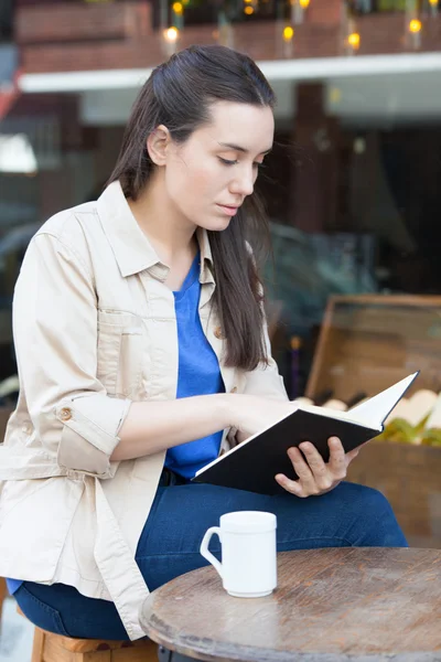 Kvinnan dricka kaffe och läsning — Stockfoto