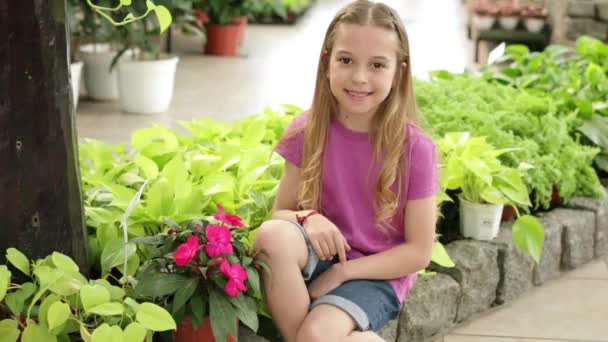 Girl sitting in greenhouse — Stock Video