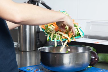 Kadın sebze bir kaseye atma