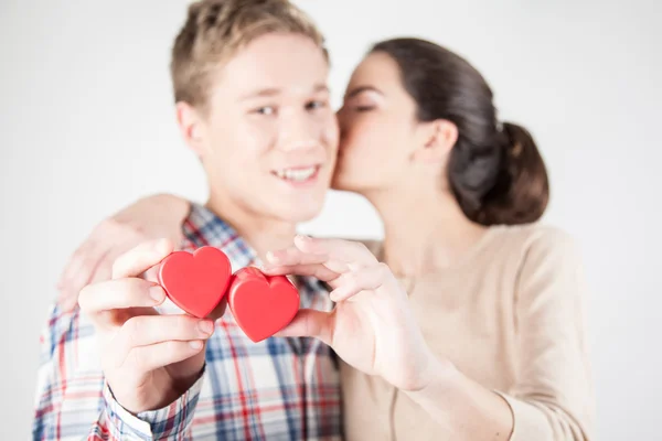 Happy couple holding red hearts