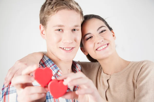 Lyckliga paret anläggning röda hjärtan — Stockfoto