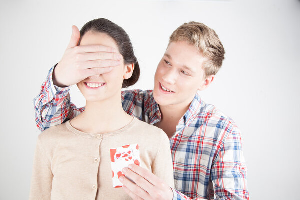 Happy boy covering girl 's eyes by hand
  