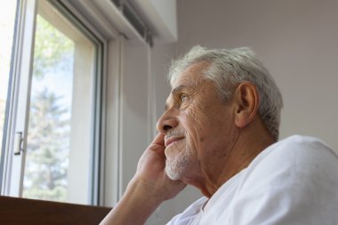 Adam için bir pencereden bakarak bir tekerlekli sandalye üzerinde 