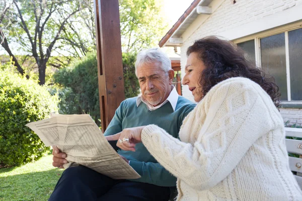 Ancianos amigos leyendo el periódico — Foto de Stock