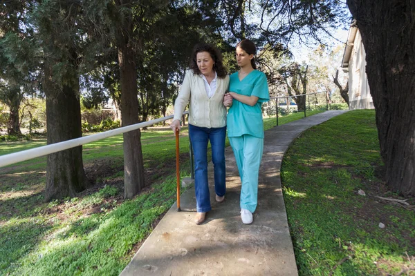 Медсестра помогает взрослой женщине — стоковое фото