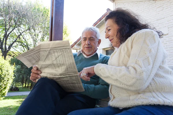 Ancianos amigos leyendo el periódico — Foto de Stock