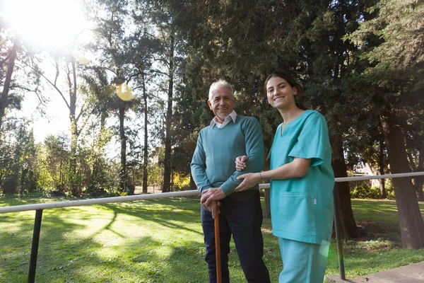 Enfermera ayudando a un anciano — Foto de Stock