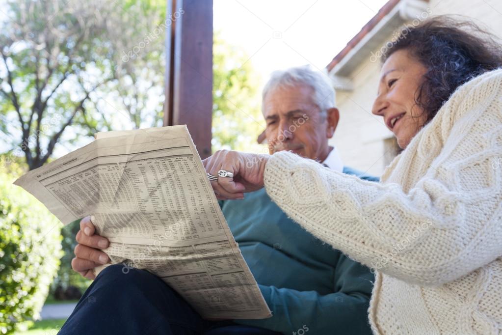 Elderly friends reading the newspaper 
