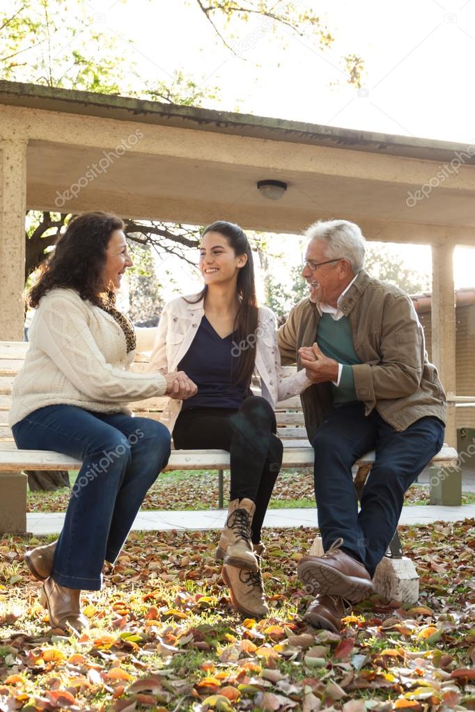 Young woman with her grandparents in autumn park 