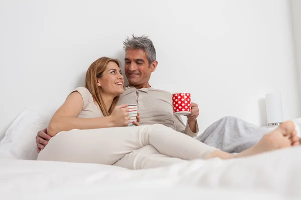 Casal beber café na cama — Fotografia de Stock