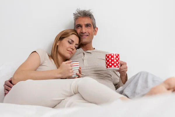 Casal beber café na cama — Fotografia de Stock