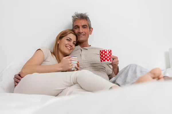 Casal beber café na cama — Fotografia de Stock