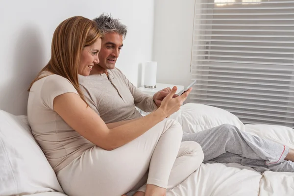 Pareja usando ipad en la cama —  Fotos de Stock