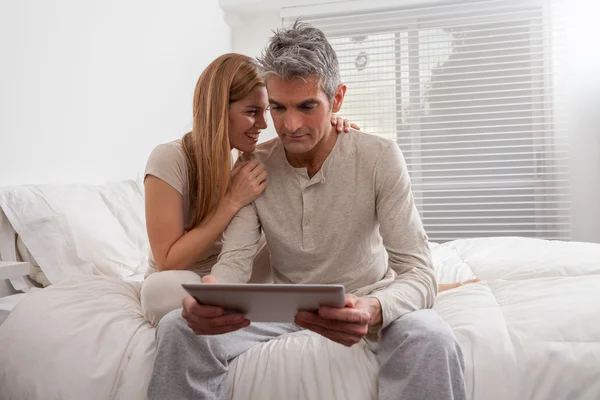 Pareja usando ipad en la cama — Foto de Stock