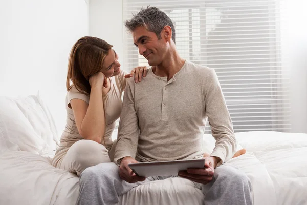 Casal usando ipad na cama — Fotografia de Stock