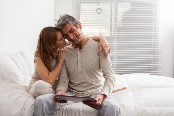 Casal usando ipad na cama — Fotografia de Stock