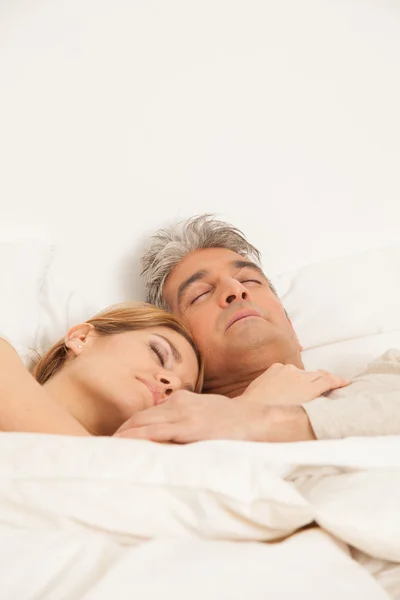 拥抱的夫妇睡在床上 — 图库照片
