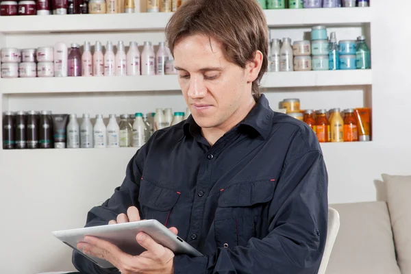 Hairstylist reads in the ipad — Stock Photo, Image